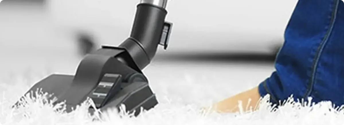 Close-up of a professional vacuuming a white carpet in Maitland.